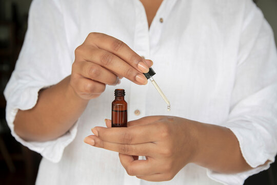 Person using essence dropper for spa skin care routine