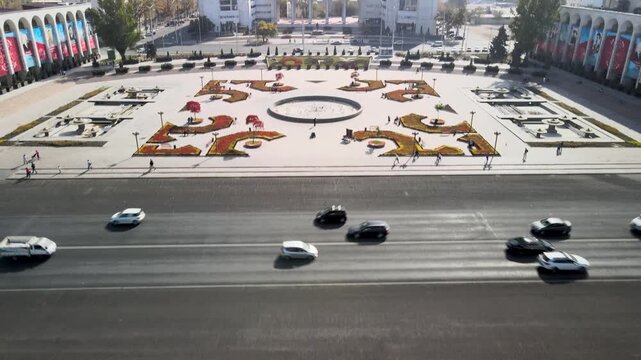 Aerial view of Ala-Too Square, the central public square of Bishkek, Kyrgyzstan. The wide open plaza, national flag, surrounding government buildings, and the urban landscape of the capital city.