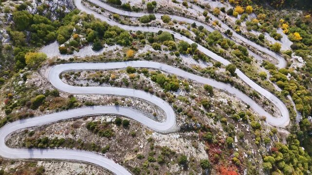 Serpentine switchback road climbing steep hillside in autumn, Vradeto, Zagori, Greece