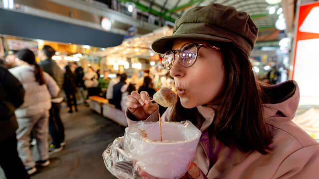Woman eating mandu dumplings at Gwangjang Market in Seoul