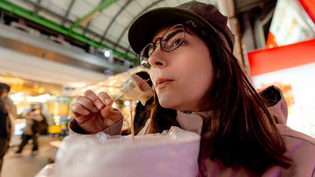 Woman eating mandu dumplings at Gwangjang Market, Seoul