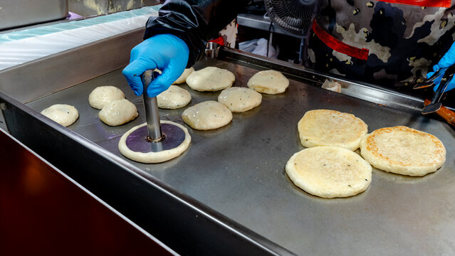 Street vendor grilling hotteok at Gwangjang Market, Seoul