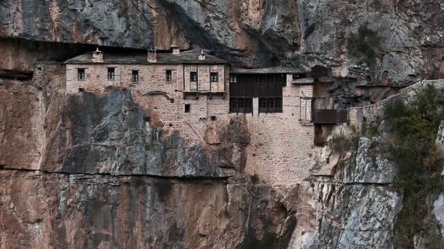 Cliff monastery clinging to massive rock wall above river gorge, Tzoumerka, Epirus, Greece