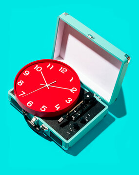 Retro record player and red clock on turquoise background