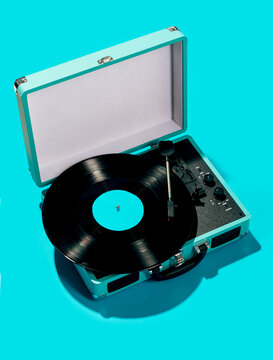 Retro vinyl record player on turquoise background