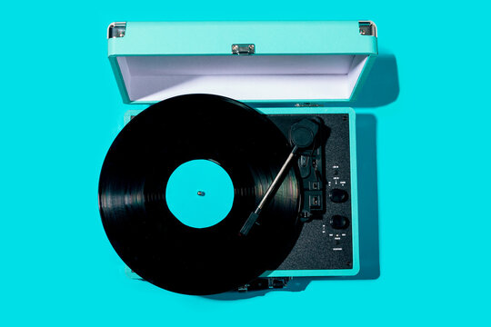 Retro vinyl record player on blue background flat lay