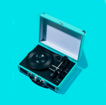 Retro suitcase turntable on blue background, vinyl vibe
