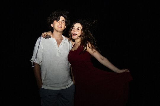 Young couple posing together at night with flash lighting
