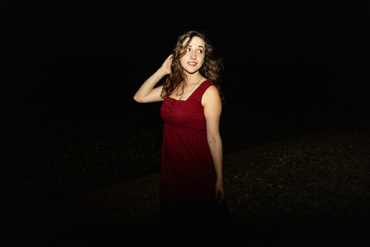 Night portrait of woman in red dress with flash lighting