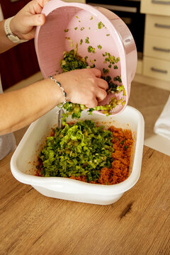 Bulgur salad with vegetables being mixed in a kitchen