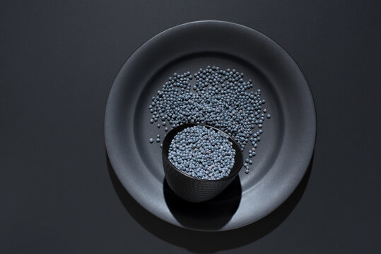 Black beluga lentils in bowl on dark plate top view