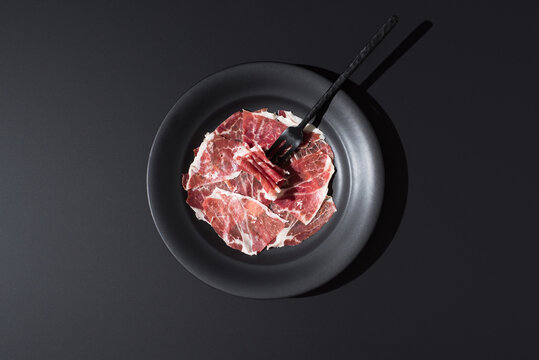 Top view of Spanish acorn-cured ham slices on plate