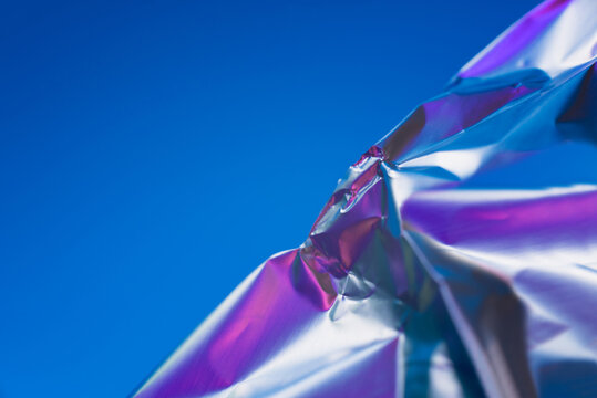 Abstract metallic sheet against vibrant blue background