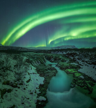 Northern lights over Bruarfoss waterfall in winter Iceland