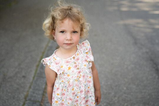 Portrait of a toddler girl in floral dress outdoors