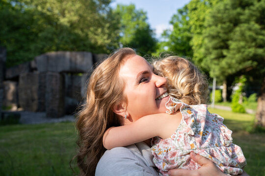 Happy mother hugging toddler girl during summer family time
