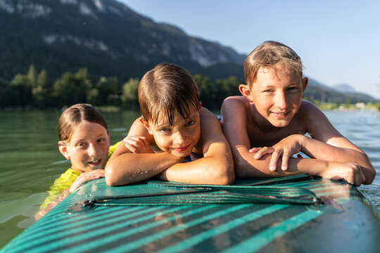 Children playing water games on a sunny summer lake day