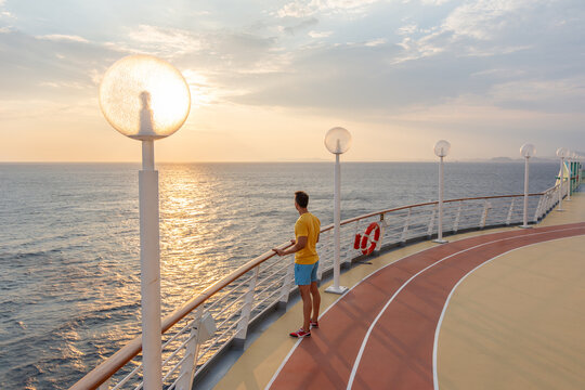 Man enjoying ocean sunset on cruise ship deck at sea