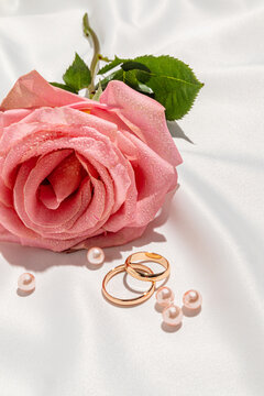 Pink rose with wedding ring pair and pearl on bridal veil