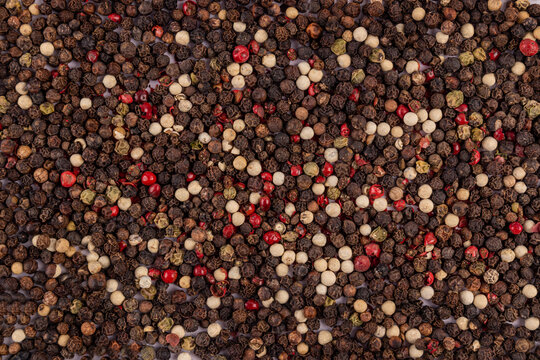 Close-up mix of black, white, and pink peppercorns