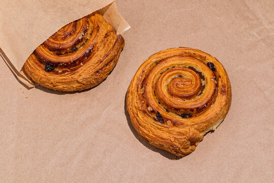 Fresh baked raisin swirl pastry on parchment paper