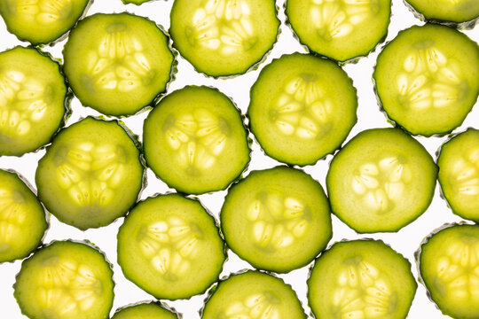 Fresh cucumber slices pattern on white background, macro