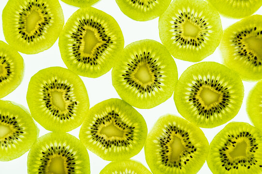 Close-up pattern of kiwi slices on white background