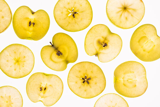 Top view of yellow apple slices pattern on white background