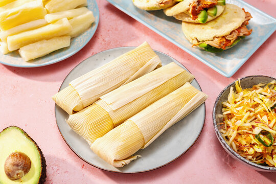 Humitas with yuca, arepas con carne, curtido and avocado