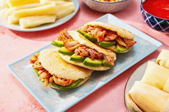 Arepas with pulled pork and avocado with Latin side dishes