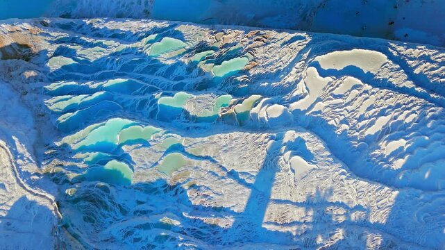Aerial view of Travertines of Pamukkale, Turkey. Layered white limestone and blue mineral water create a unique natural texture.