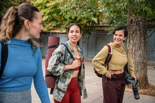 Multiethnic women with backpacks walking to outdoor class