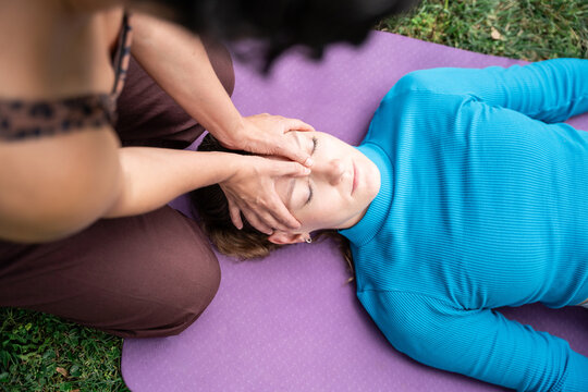 Holistic head massage session for women on yoga mat