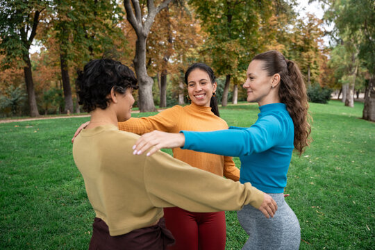 Mindful group hug in autumn park during spiritual retreat