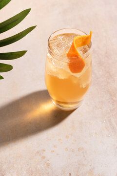 Refreshing cocktail with orange garnish on table