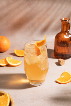 Refreshing orange cocktail with citrus slices and bottle