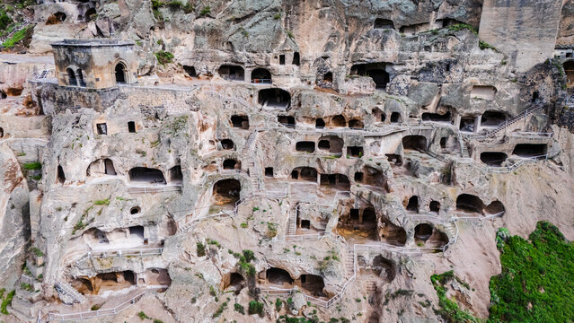 Drone close up  of Vardzia cave monastery, Georgia. Aerial of Spectacular ancient rock-hewn fortress carved into Erusheti Mountain slopes above the winding Mtkvari River