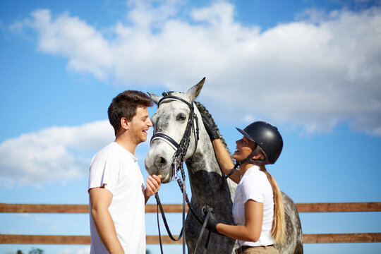 Woman and man enjoying time with horse outdoors
