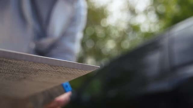 Worker smoothing and cleaning the edge of a ceramic tile after cutting. Finishing process with hand tool, 