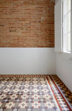 Minimal empty room with brick wall and patterned tile floor