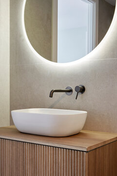 Modern bathroom vanity with round mirror and vessel sink