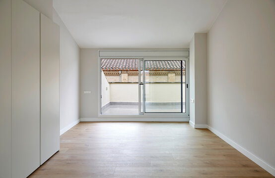 Empty modern room with sliding glass door and balcony