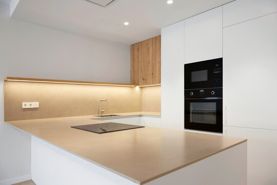 Modern minimalist kitchen with island and built in oven