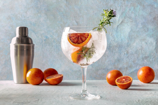 Refreshing Gin and Tonic with orange and rosemary garnish
