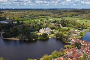 Fototapeta premium Aerial drone footage of Beaulieu village in Hampshire, England, showcasing a historic rural settlement surrounded by the New Forest countryside
