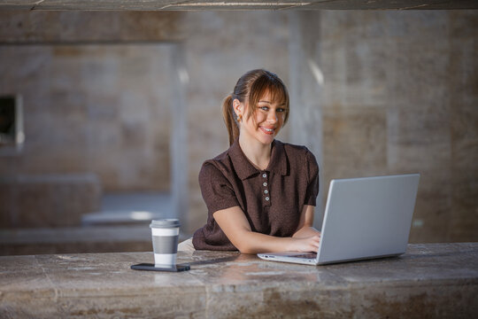 Woman working on laptop in a public park setting