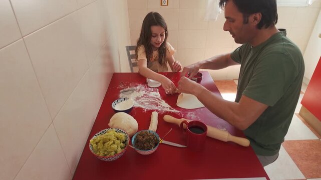 Father and Daughter Joyfully Bond Making Traditional Vareniki Dumplings Together in the Kitchen
