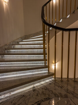 Elegant marble staircase with brass railing and lighting