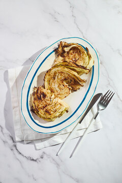 Roasted cabbage steak with blue cheese sauce on platter