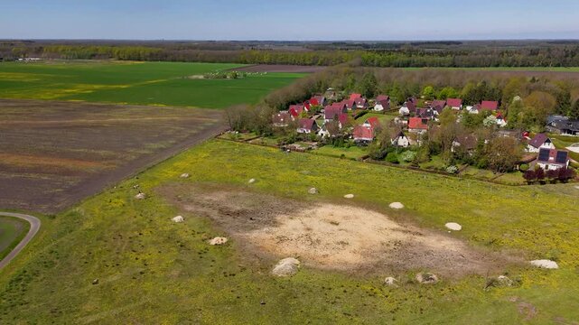 Aerial view flying over a dolmen archaeological site near a village